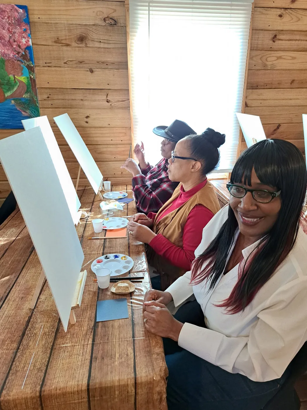 Guests gathered around canvases for a painting activity