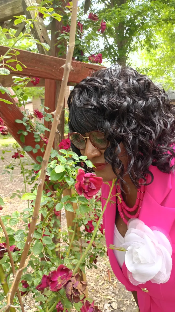 Visitor leaning toward flowers in the farm garden