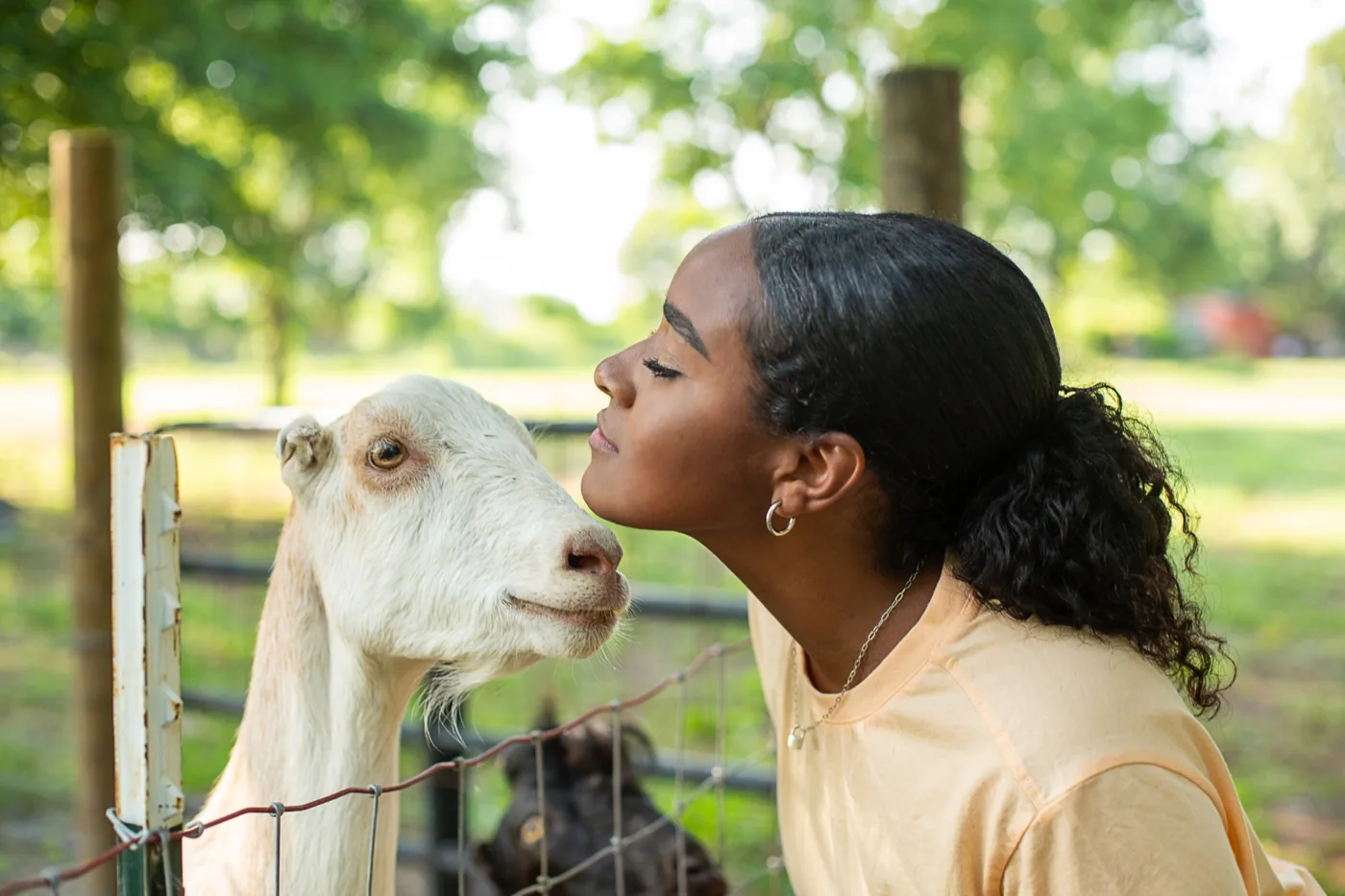 Visitor beside a goat at Young Family Farm